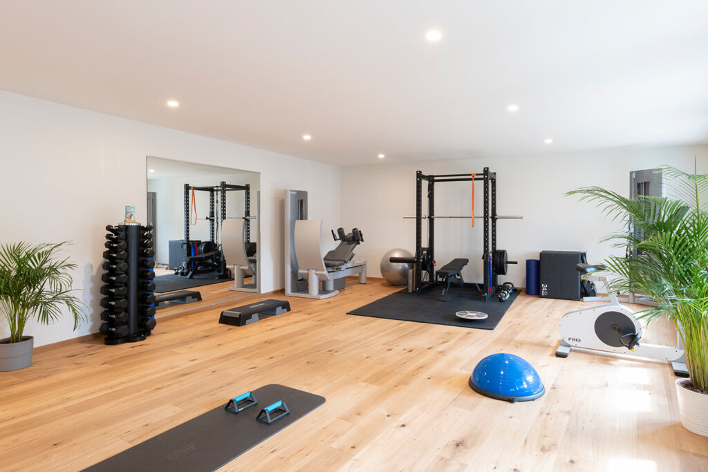 Physiotherapie Praxis Silea Basel - Lichtdurchfluteter Trainingsraum mit Holzboden und Trainigsgeräten